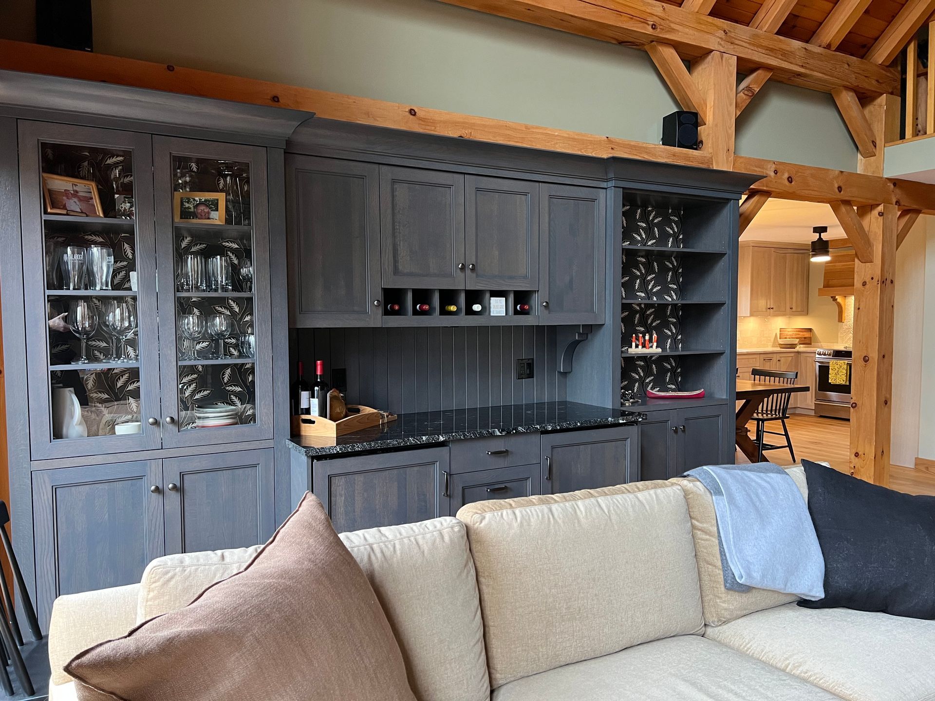 A living room with a couch , cabinets and a bar