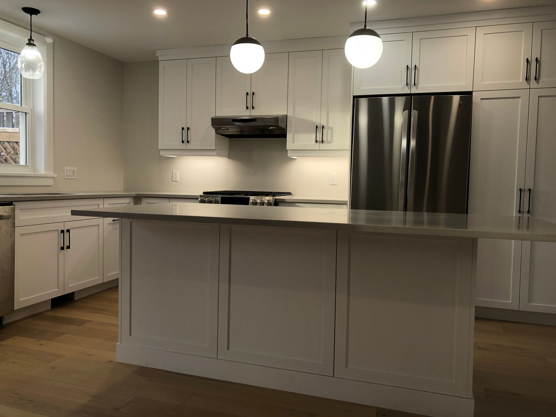 A kitchen with white cabinets and stainless steel appliances
