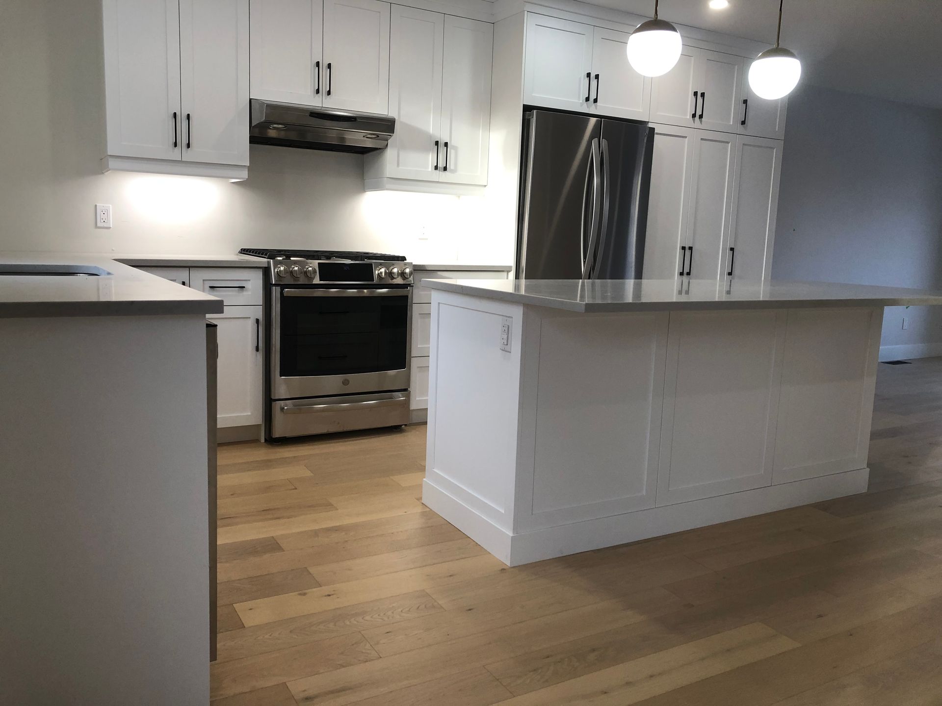 A kitchen with white cabinets and stainless steel appliances
