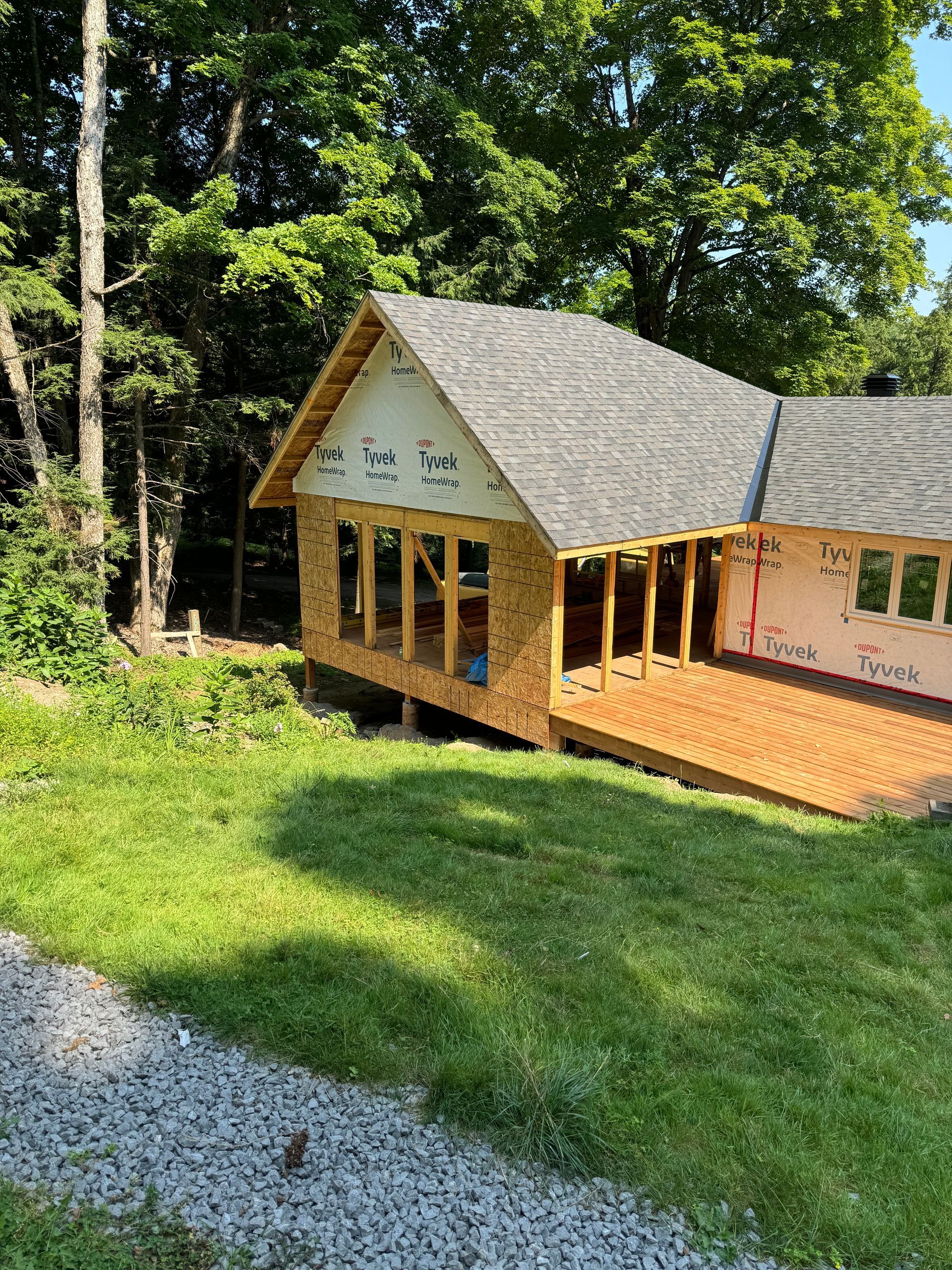 A house is being built on a hill in the woods.
