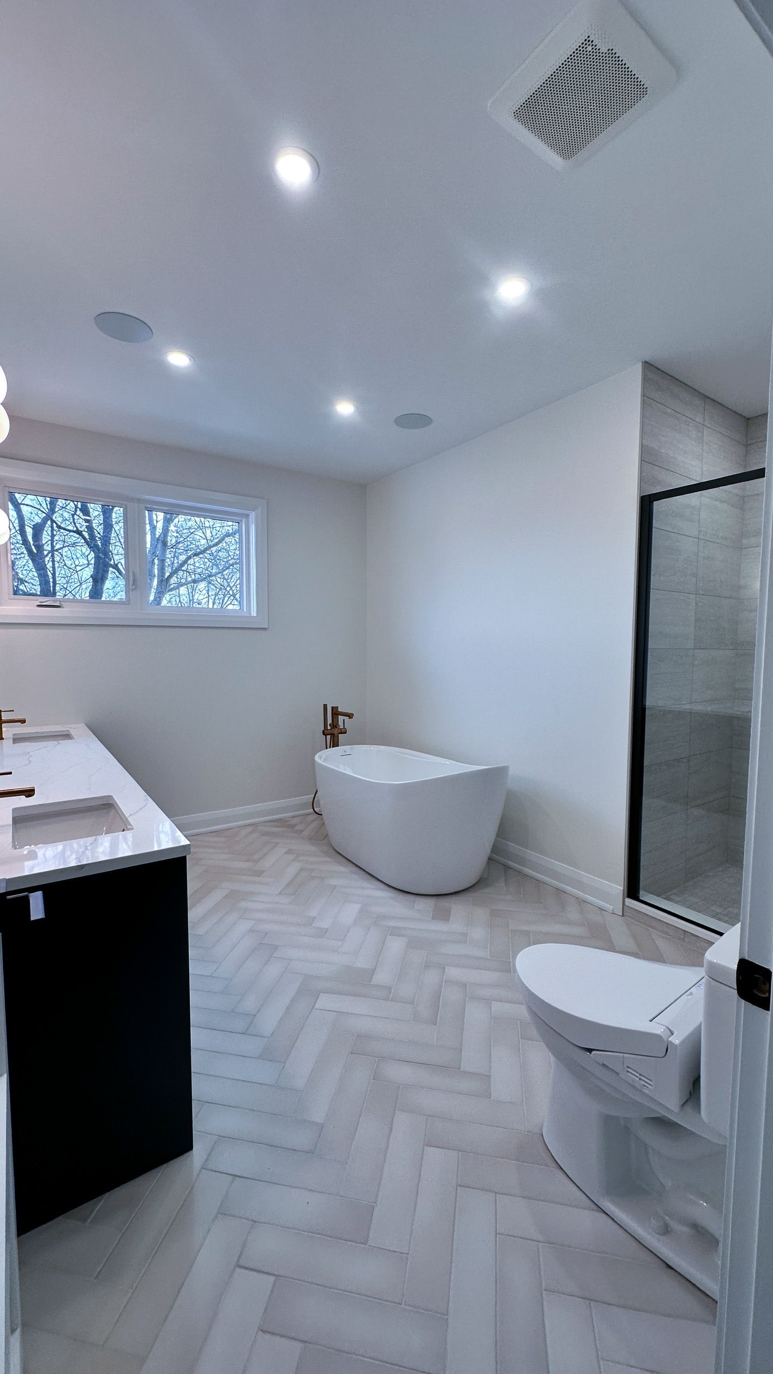 A bathroom with a tub , toilet , sink and shower.