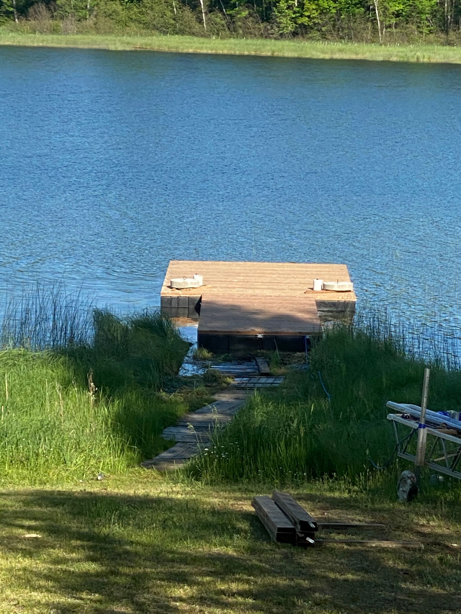 A wooden dock is sitting on the shore of a lake.