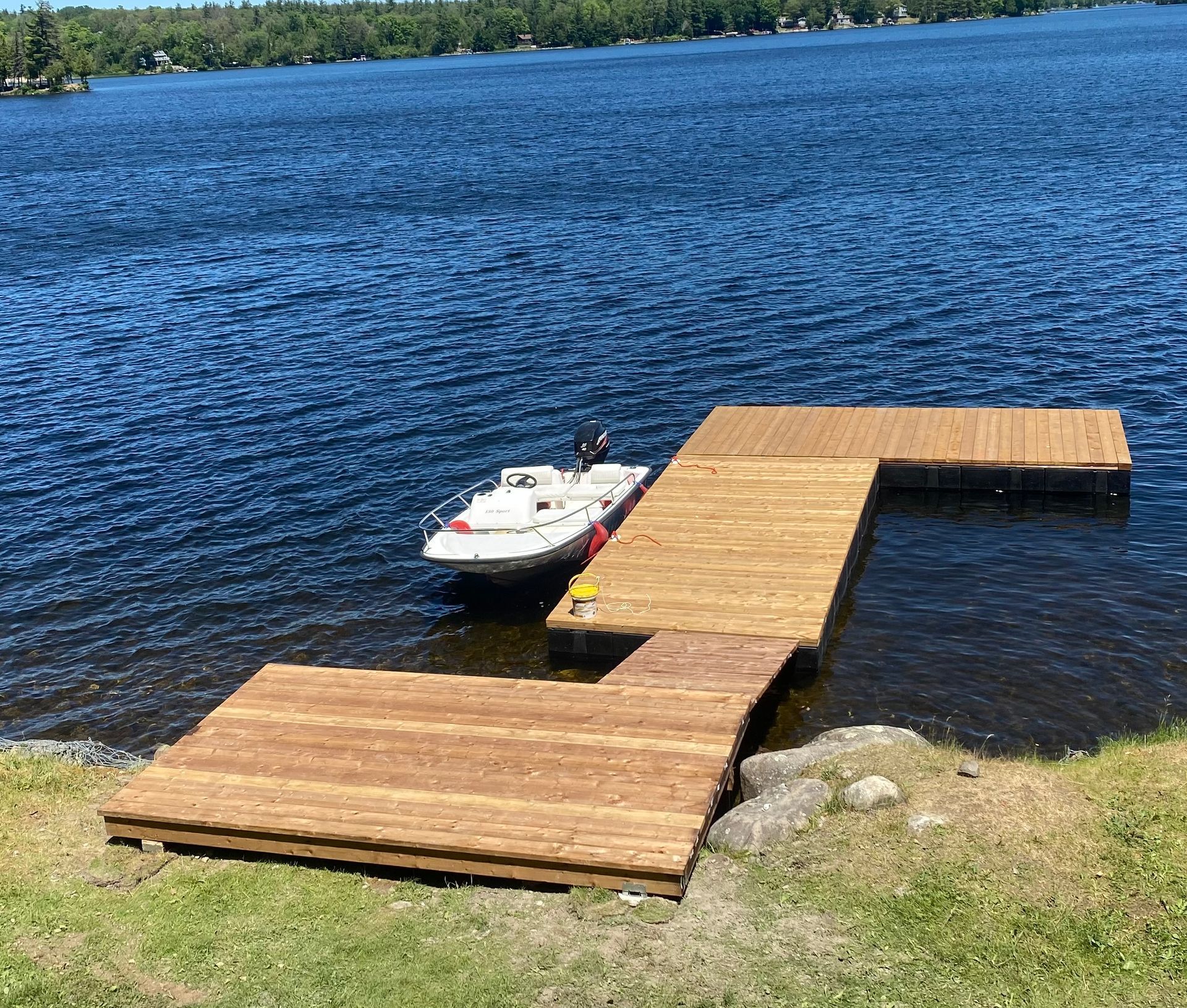 A boat is docked at a wooden dock on a lake.