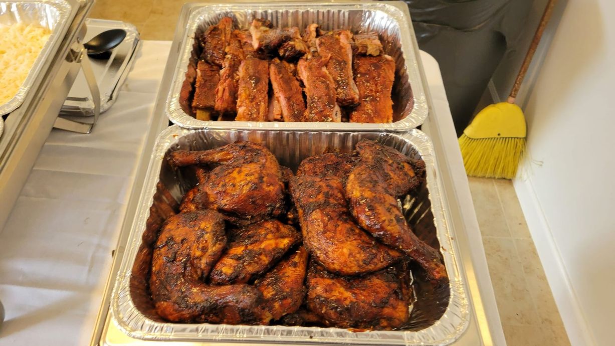 A tray of chicken wings and ribs on a table.