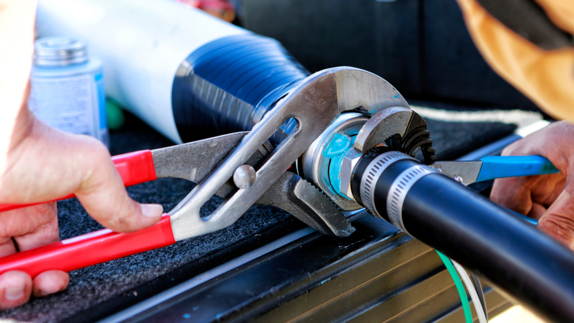 A person is working on a pipe with a wrench.