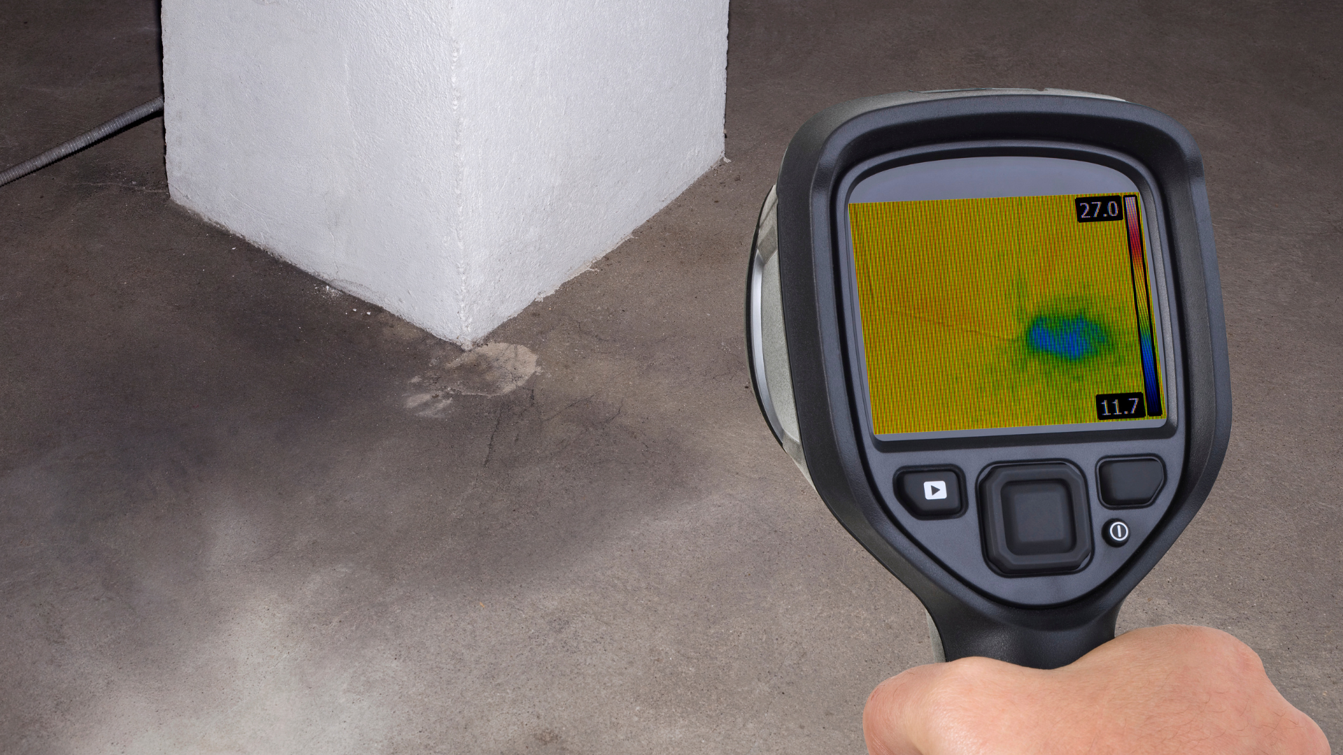 A person is holding a thermal camera in front of a cube.