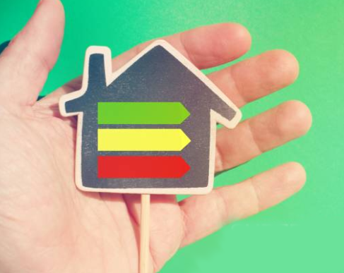 Una mano tiene una casetta su un bastone.