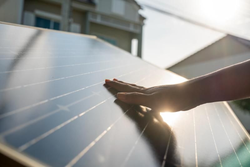 Una persona tocca un pannello solare con la mano.