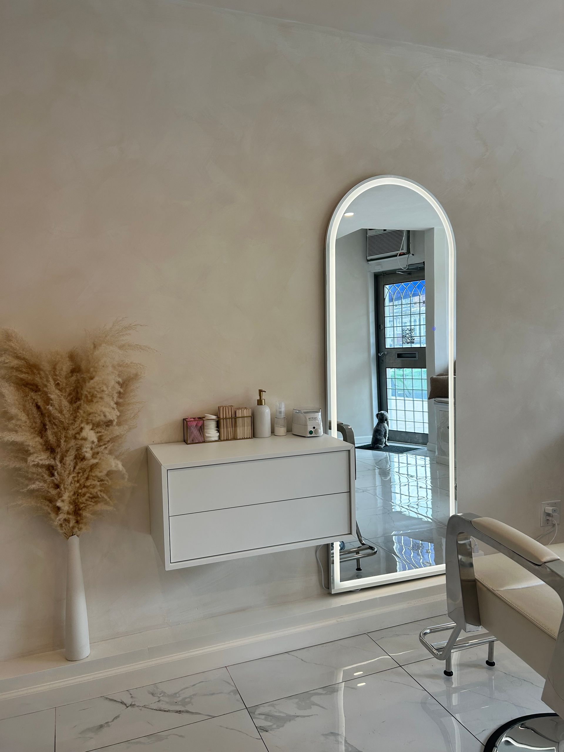 A room with two chairs and a neon sign that says `` a self care beauty studio ''.