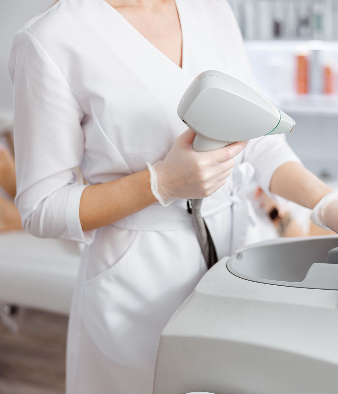 A woman is holding a machine in her hands while wearing gloves.