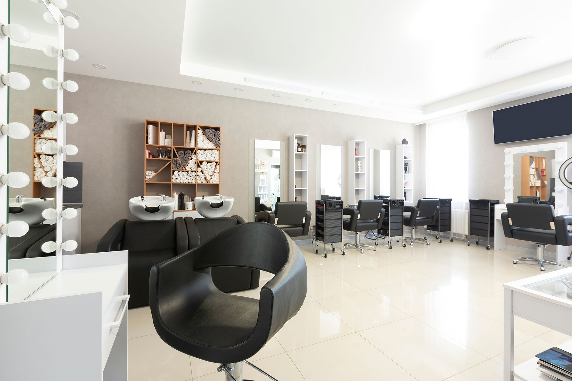 A hair salon with a lot of chairs and a mirror.
