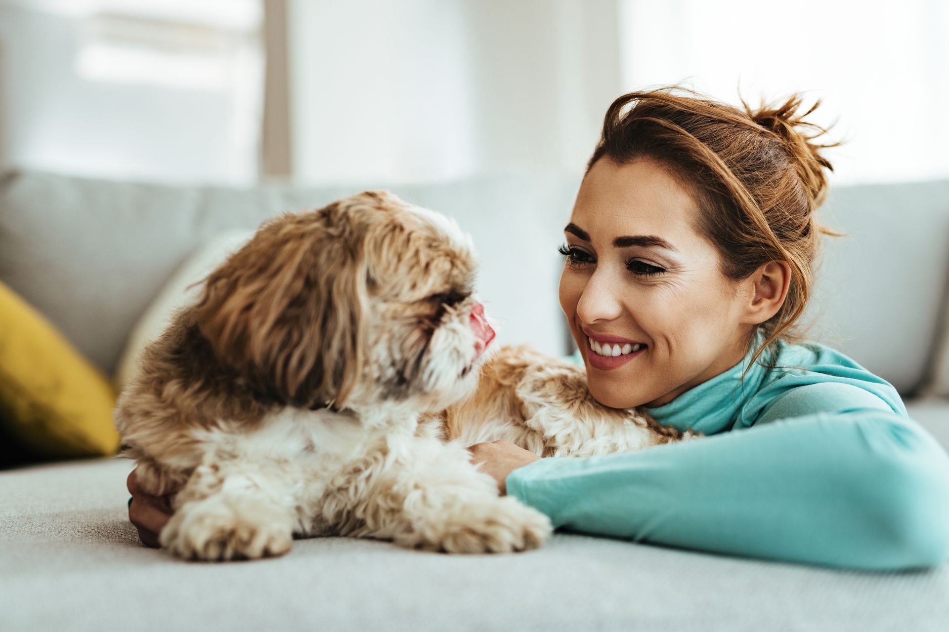 young happy woman enjoying with her dog home
