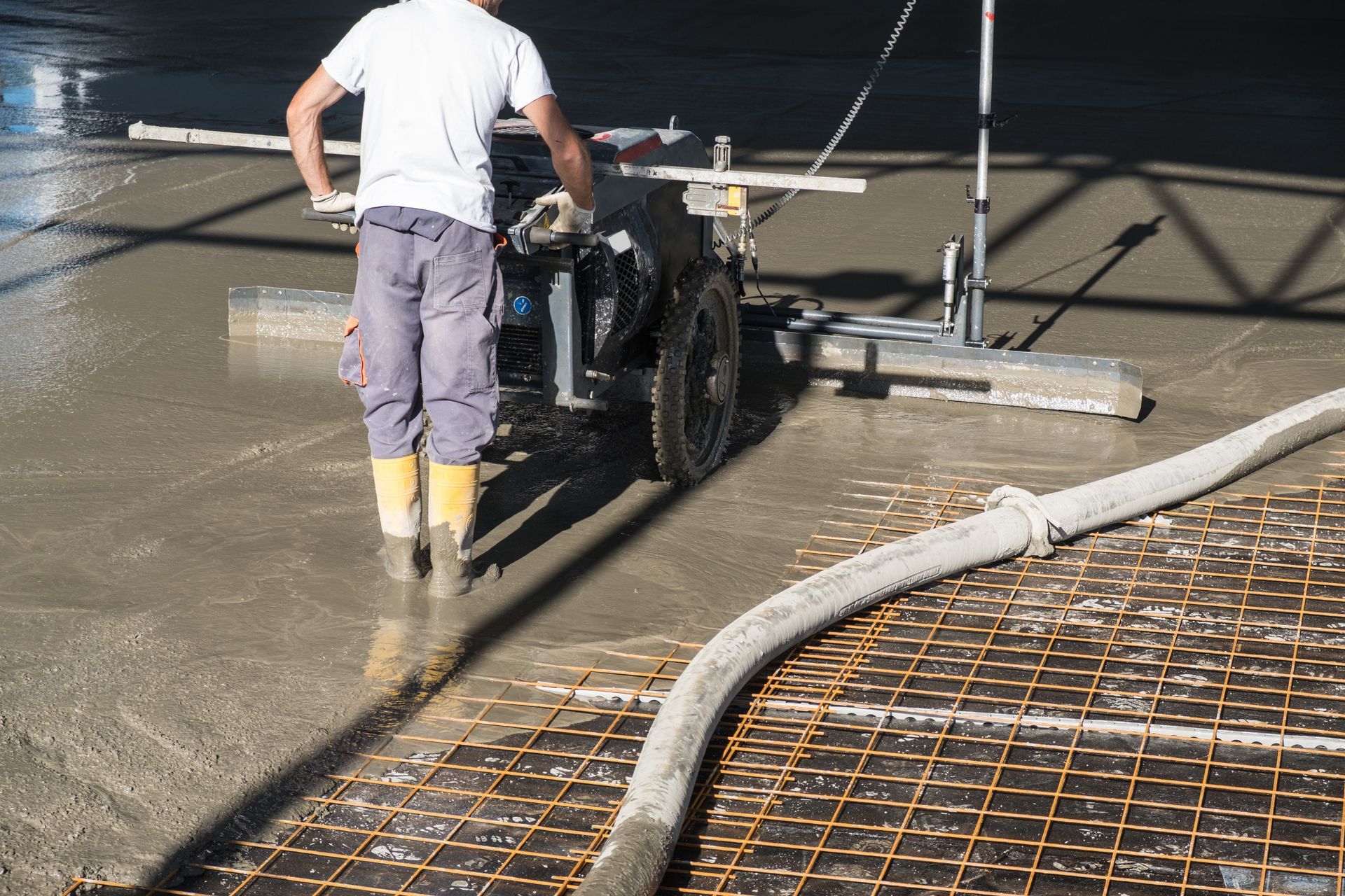 A man is working on a concrete floor with a machine.