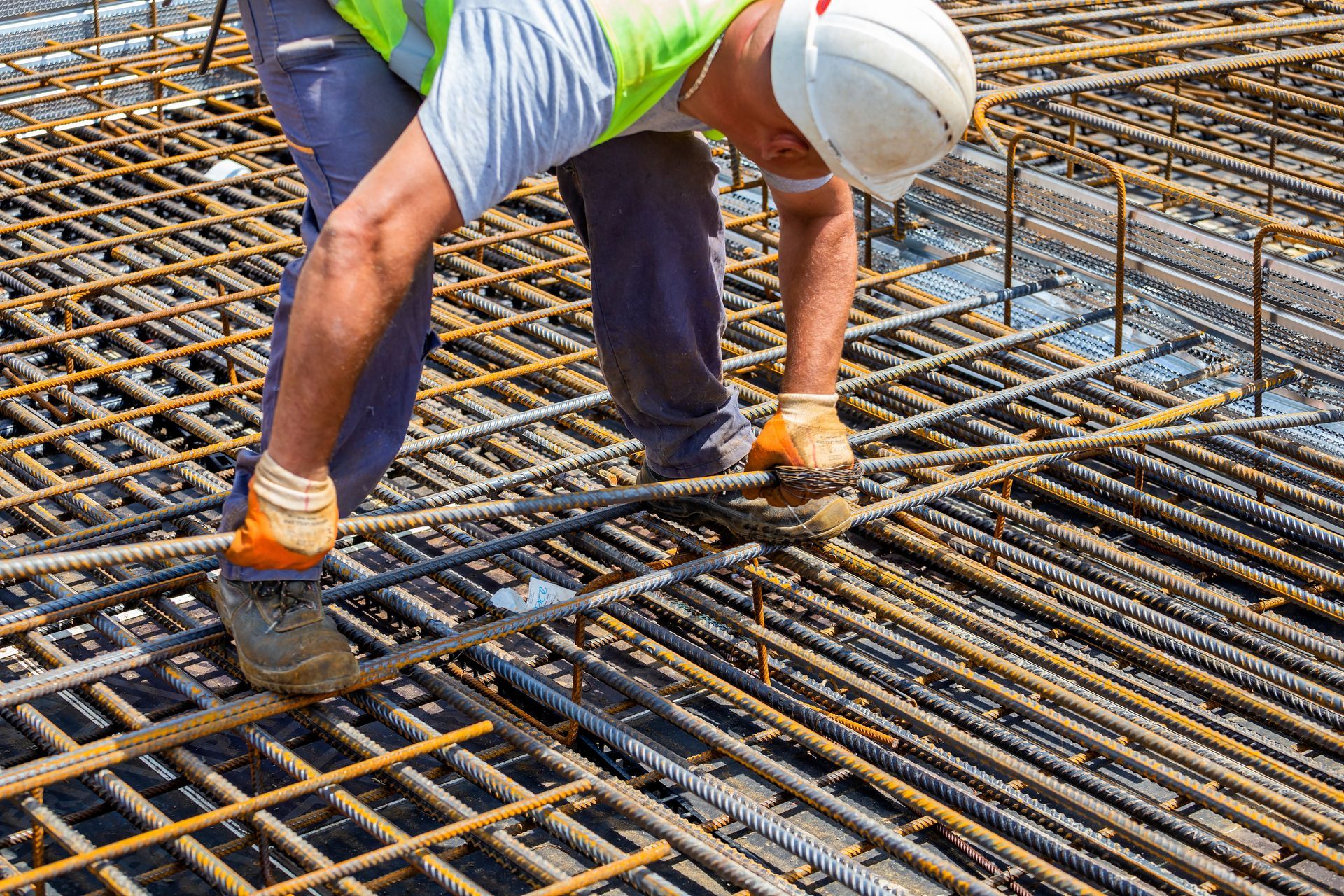 A construction worker is working on a concrete floor.
