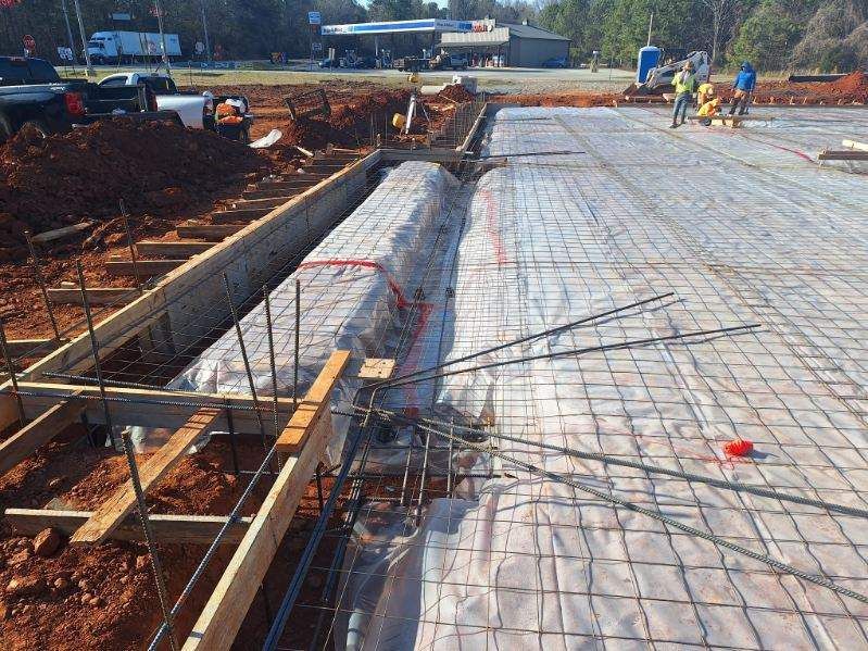 A group of construction workers are working on a concrete floor.