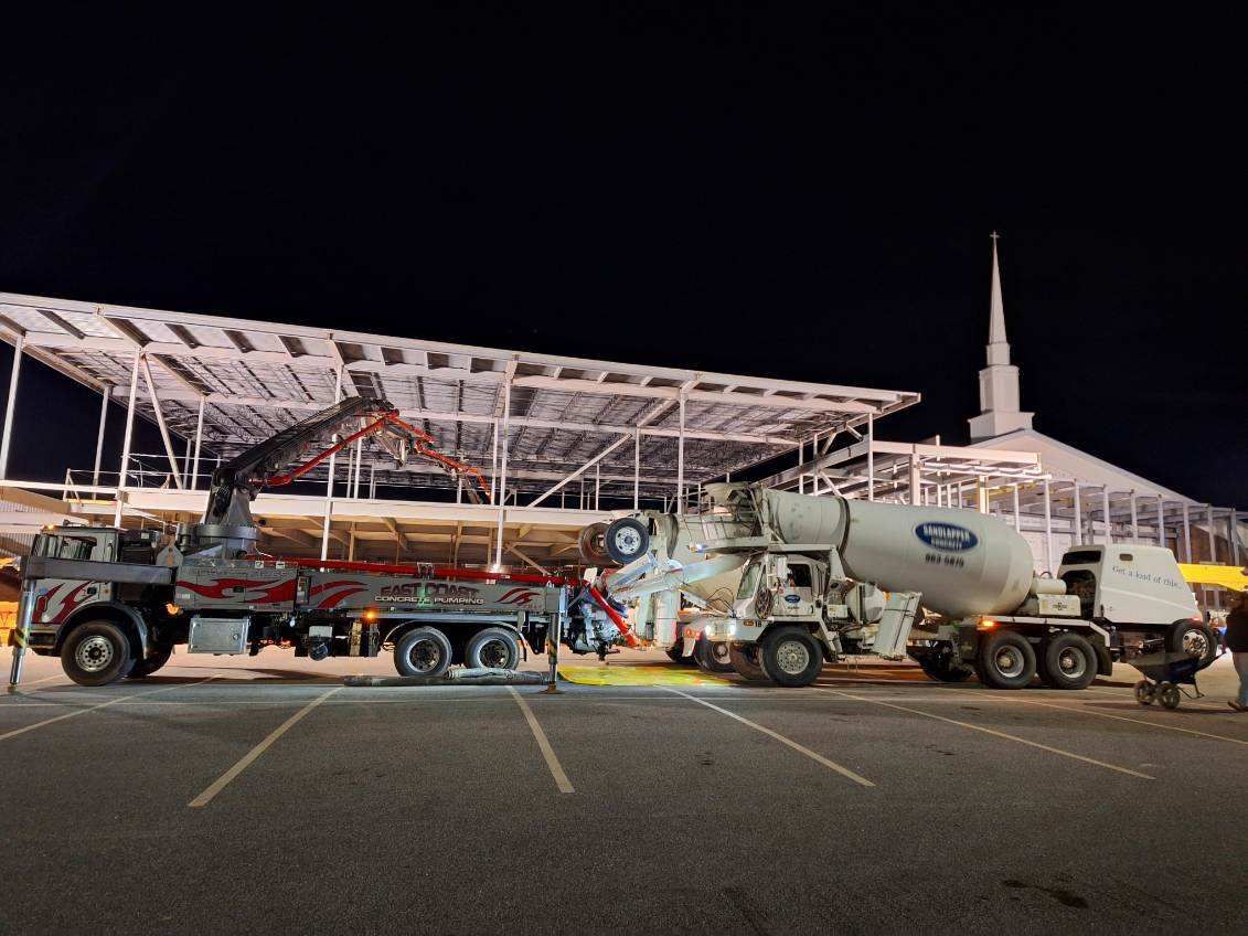 A couple of trucks are parked in a parking lot in front of a building.