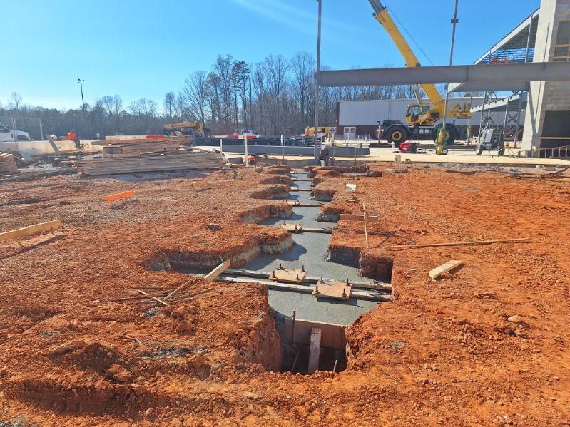 A construction site with a lot of dirt and a crane in the background.