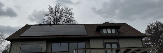 A house with a lot of windows and solar panels on the roof.