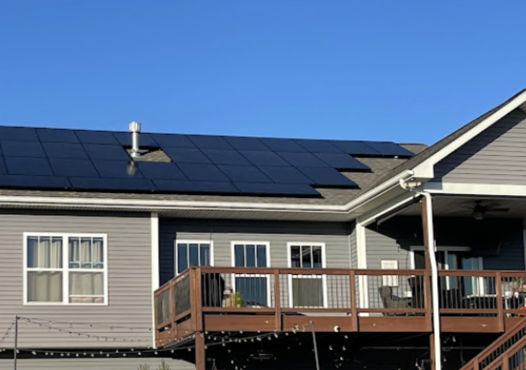 A house with a deck and solar panels on the roof