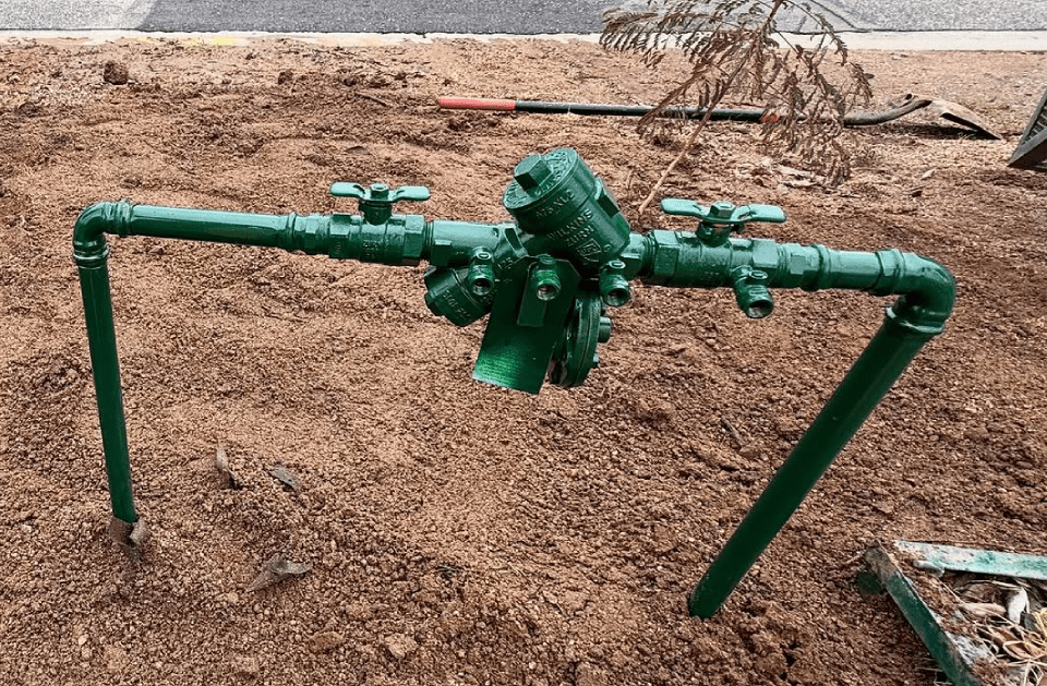 Green irrigation system installed in brown dirt.