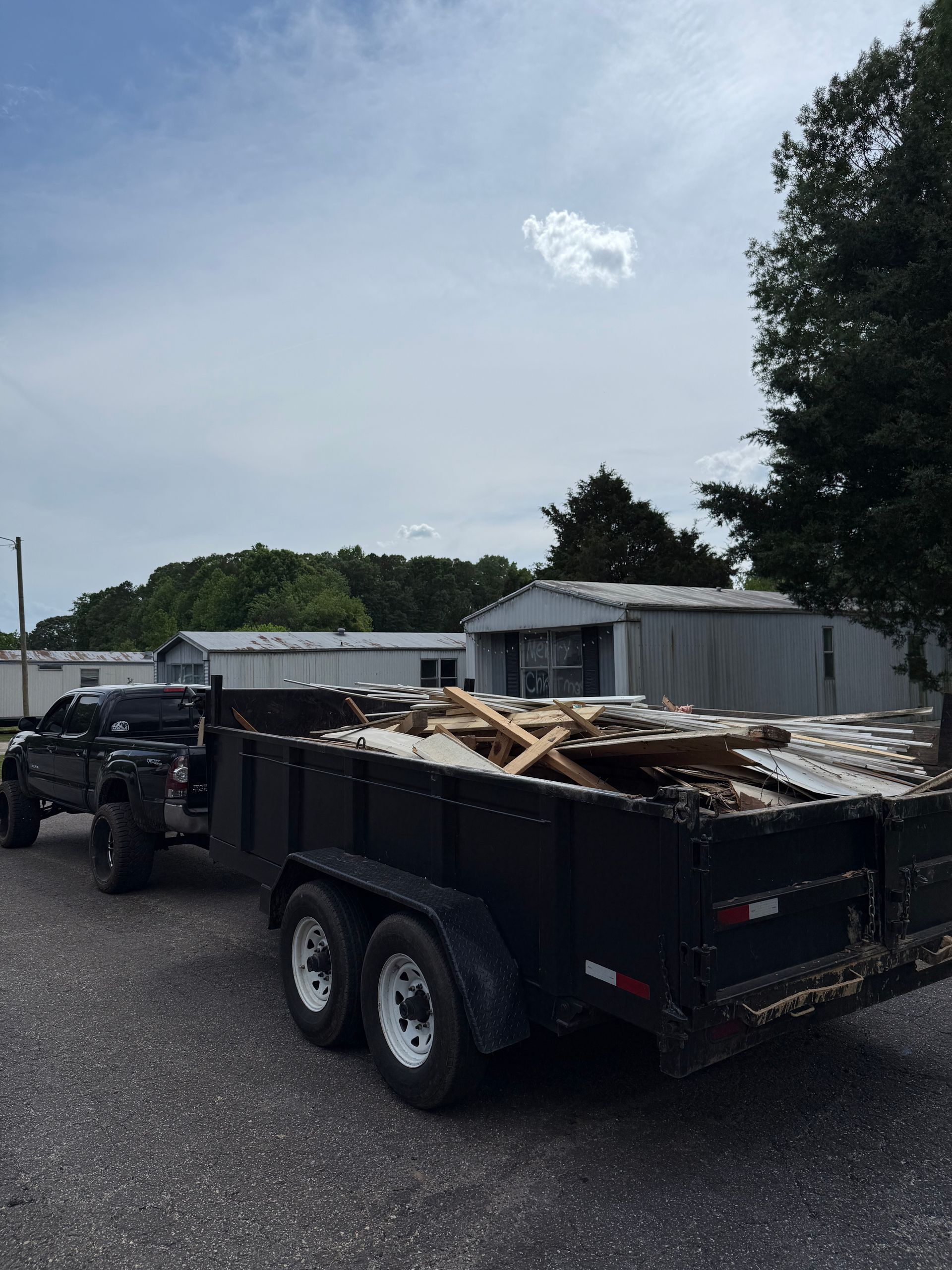 A dump truck is pulling a trailer full of wood