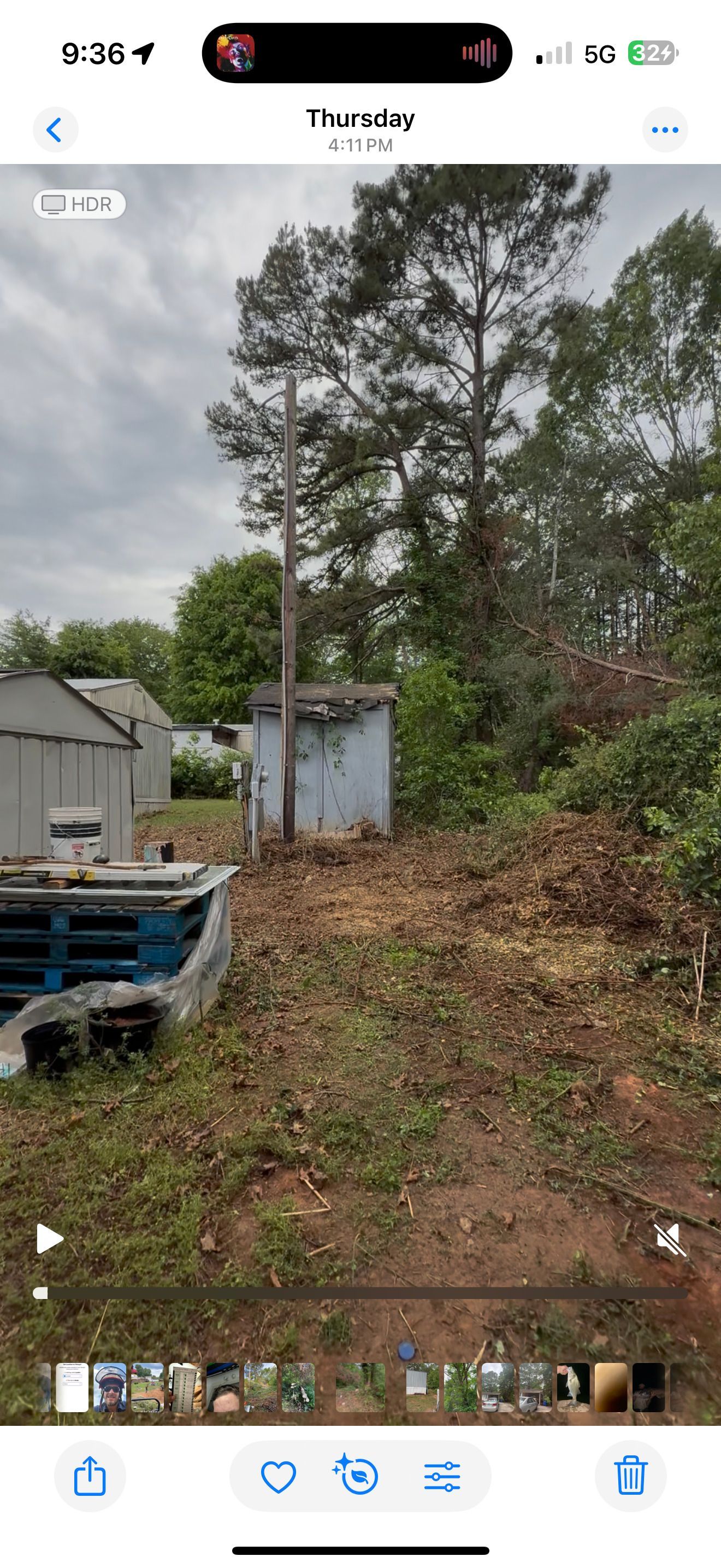 A phone screen shows a picture of a yard with a shed and trees.