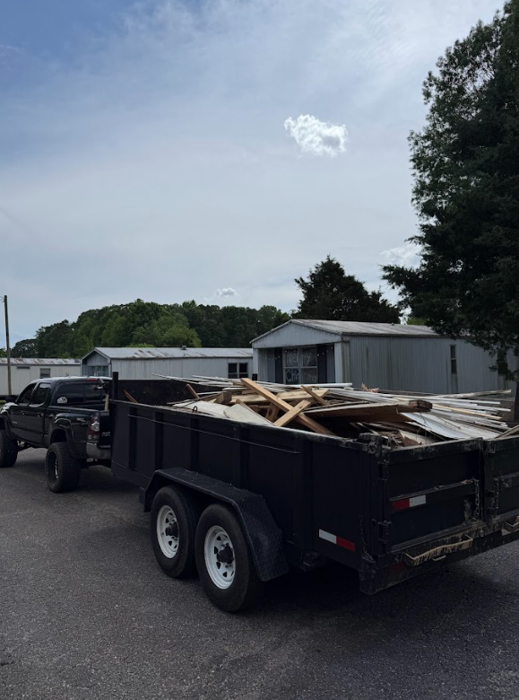 A dump truck is pulling a trailer full of wood