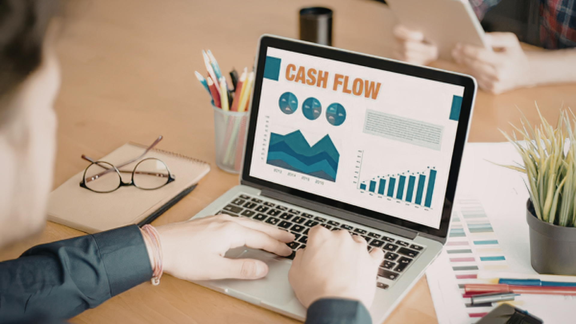 A corporate financial analyst checking real-time cash flow inflows and accounts receivable data on a dashboard.
