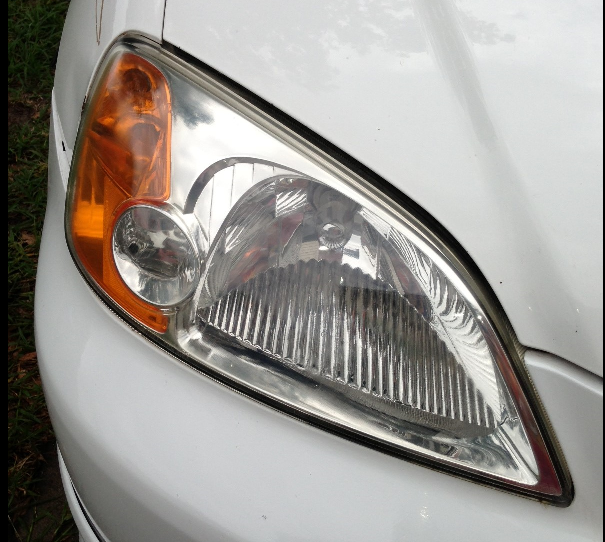 A close up of the headlight of a white car