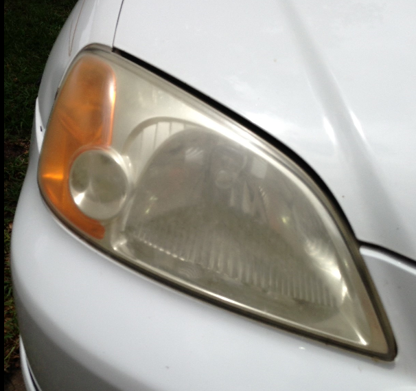 A close up of a white car 's headlight