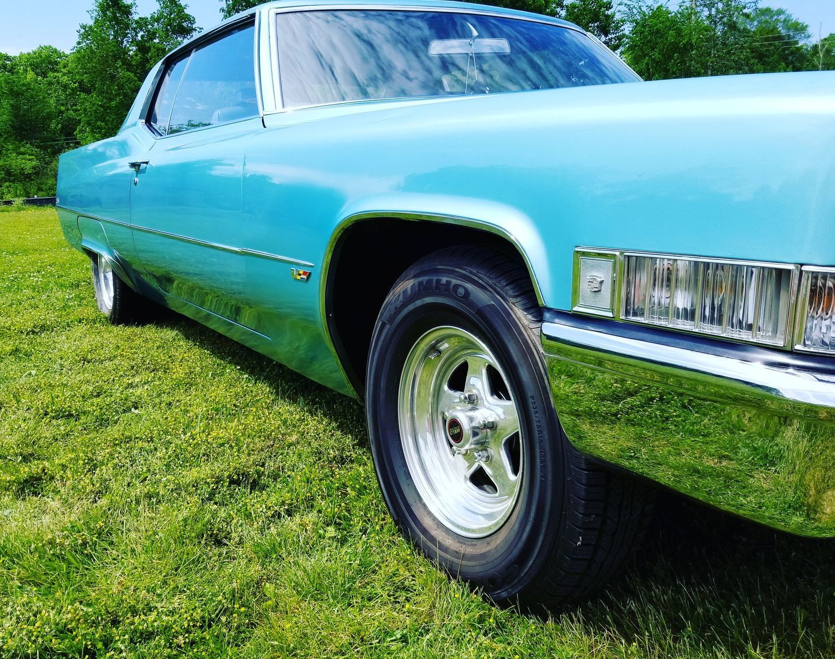 a person wearing black gloves is cleaning a car with a towel .