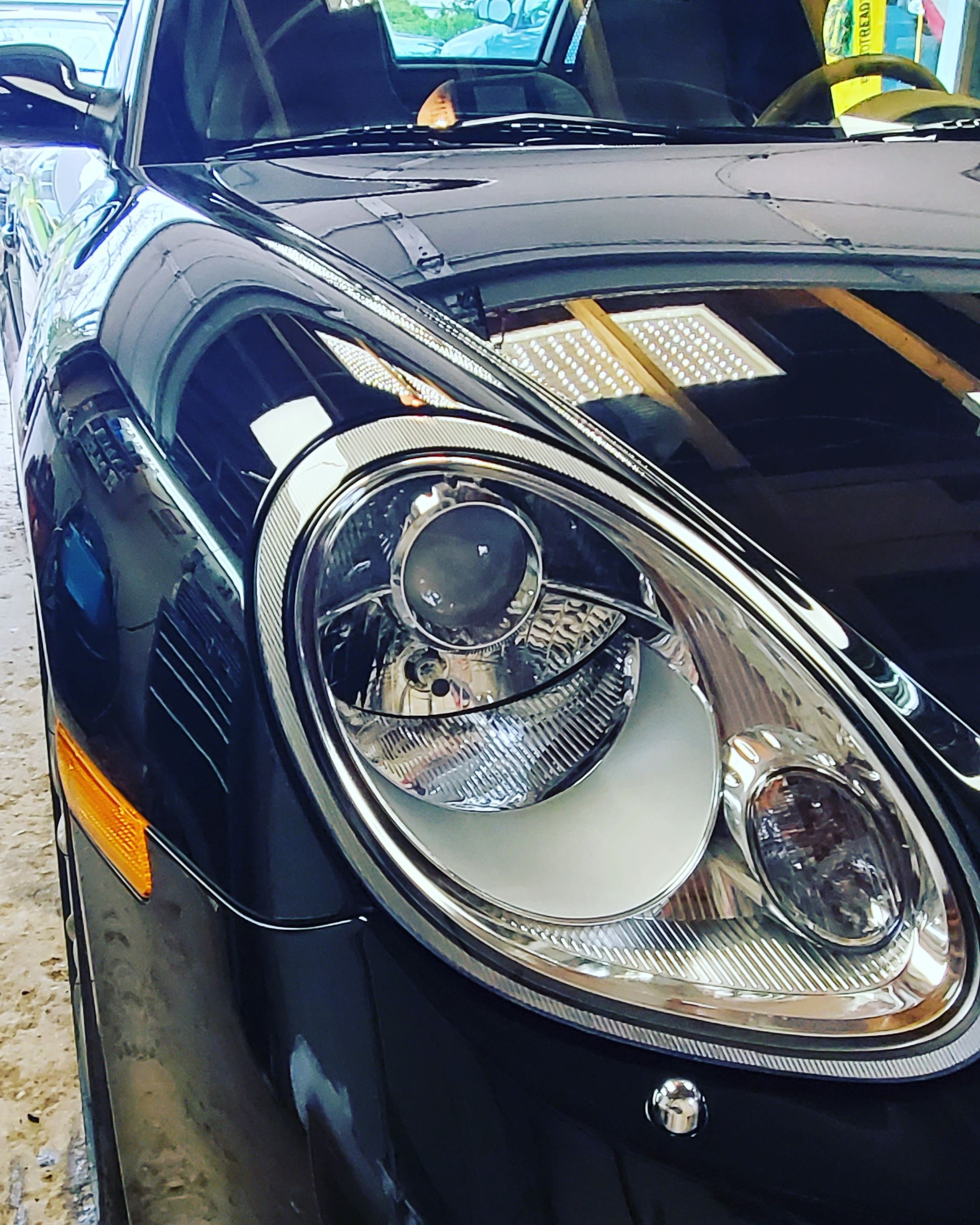 a man is polishing the hood of a car with a machine .