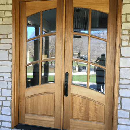 A Pair Of Wooden Doors With Glass On A Brick Wall — Somerset, KY — Somerset Burnside Garage Door & Glass Co Inc