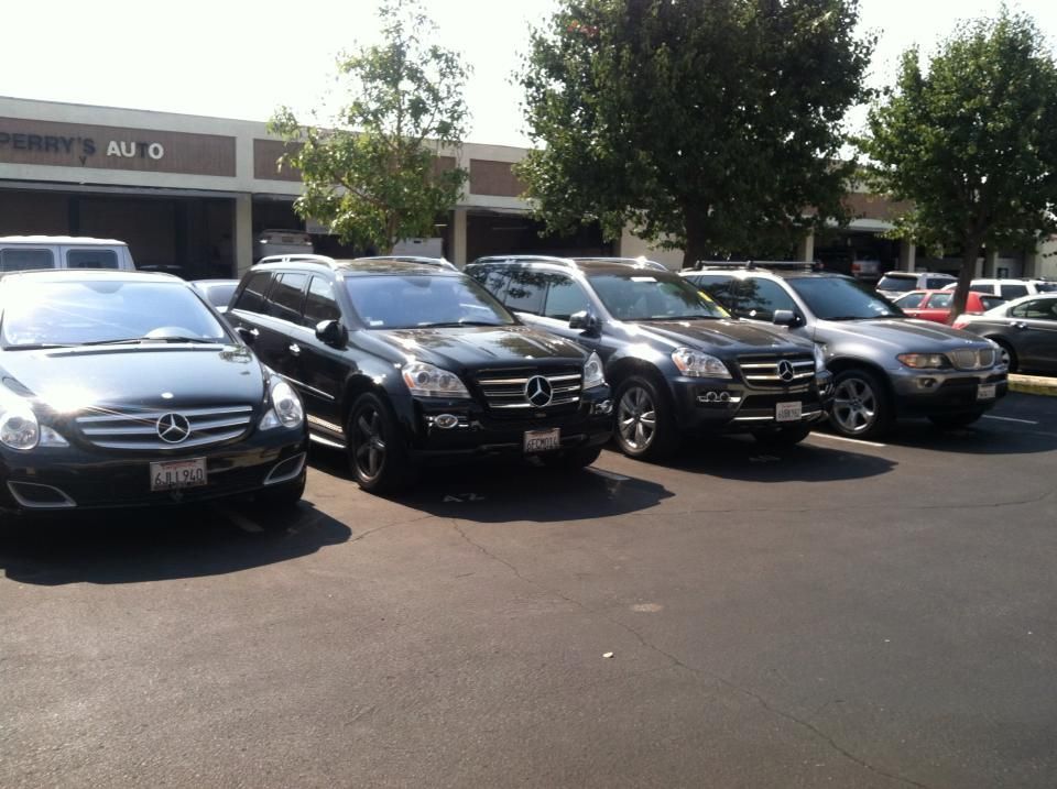 Row of black SUVs parked in front of a strip mall on a sunny day. Row of black SUVs parked in front of a strip mall on a sunny day.