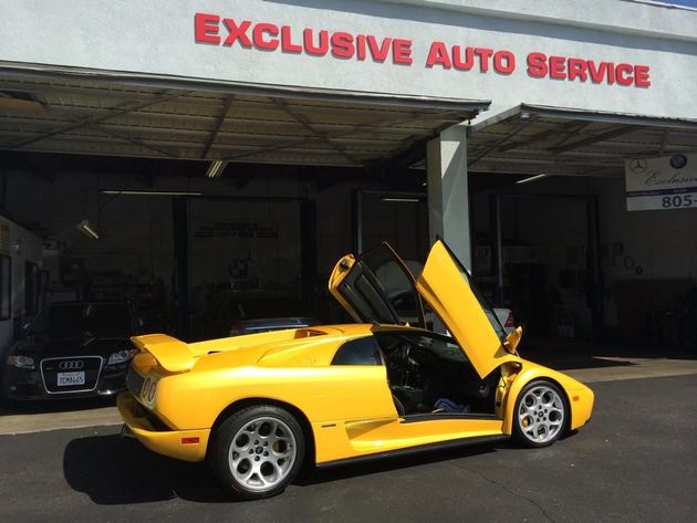 Yellow Lamborghini with doors up in front of  Yellow Lamborghini with doors up in front of