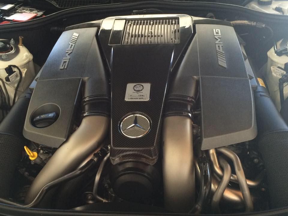 Mercedes-AMG engine with black covers, silver intake tubes, and the AMG logo. Mercedes-AMG engine with black covers, silver intake tubes, and the AMG logo.
