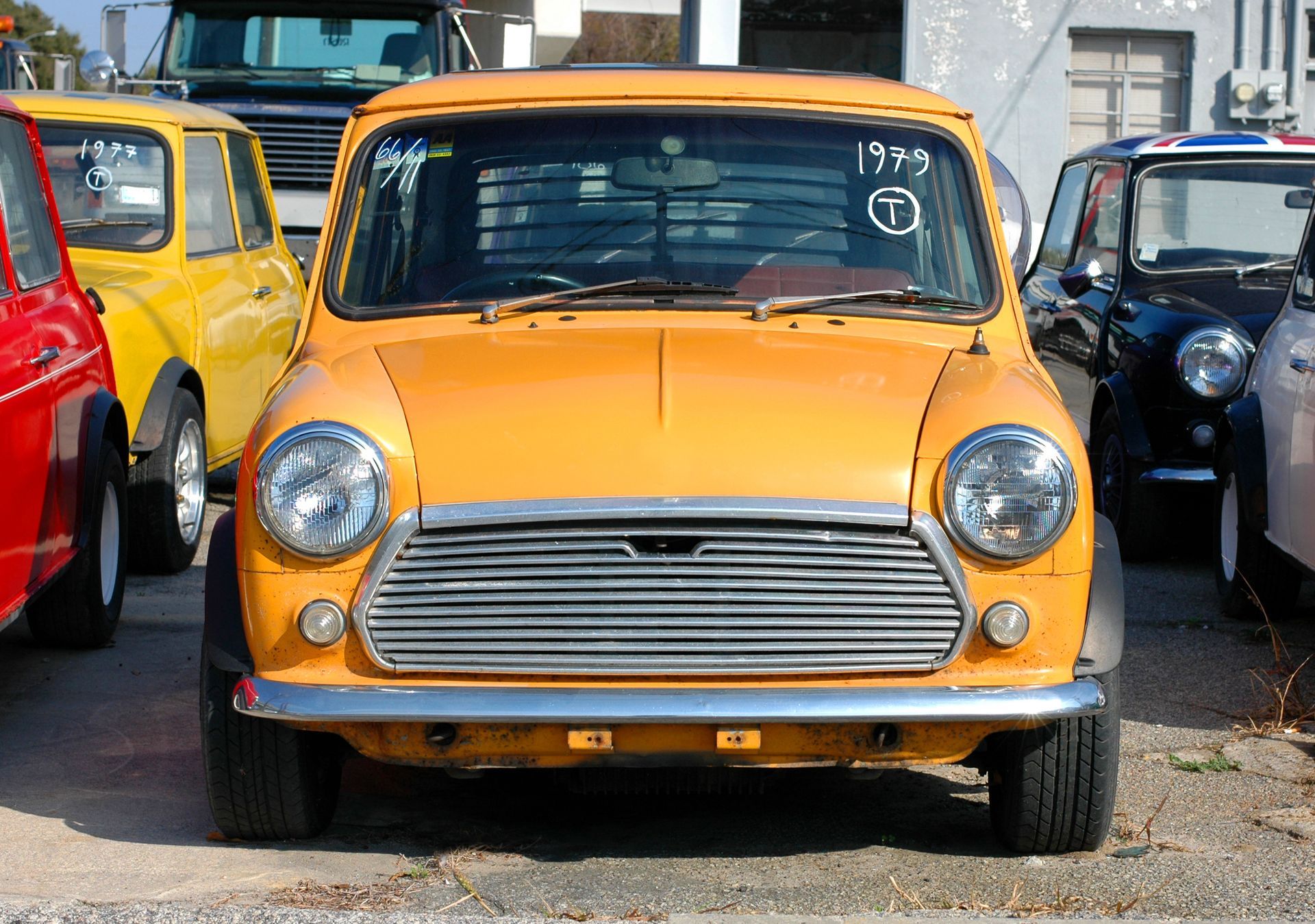 Yellow Mini Cooper car, parked with other classic cars.