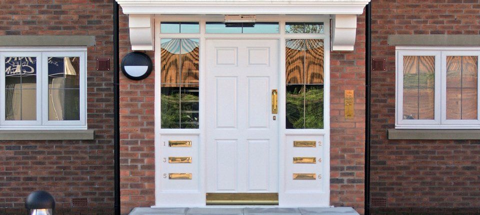 An attractive front door with individual letter boxes for each flat above