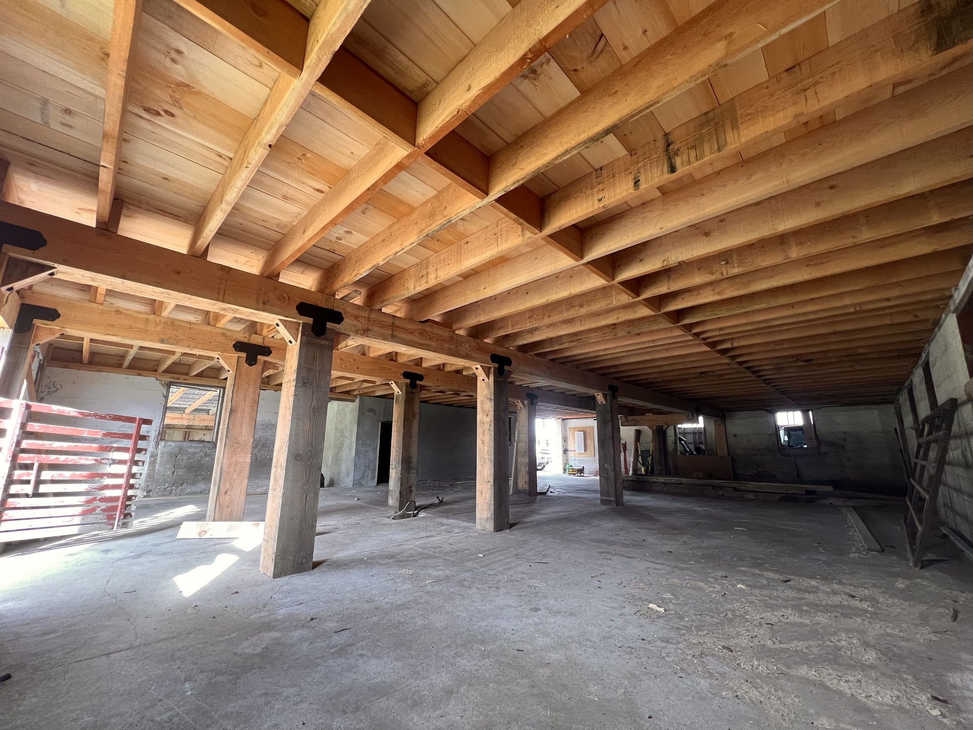 A large empty room with a wooden ceiling and pillars