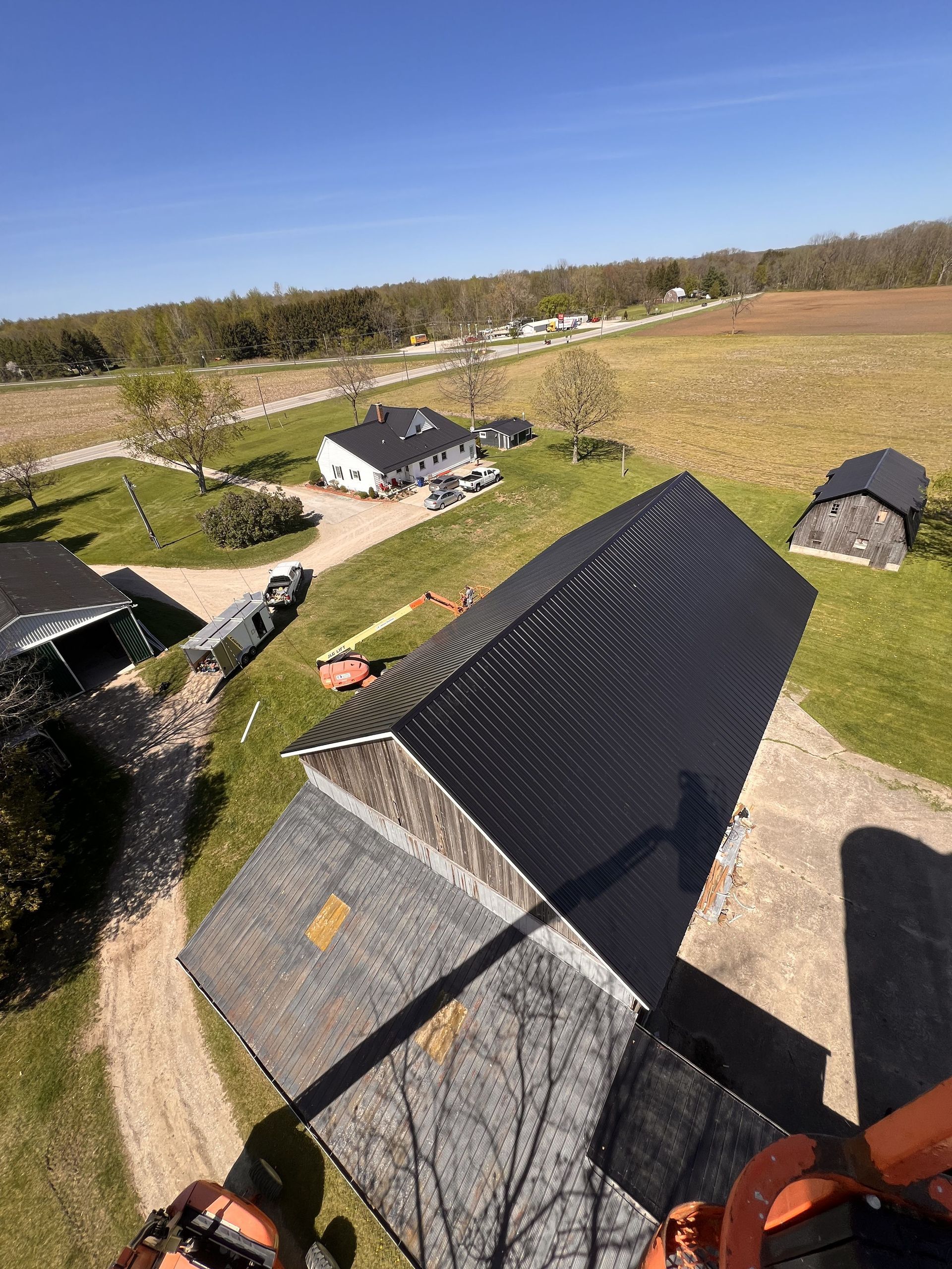 An aerial view of a house with a black tarp on the roof.