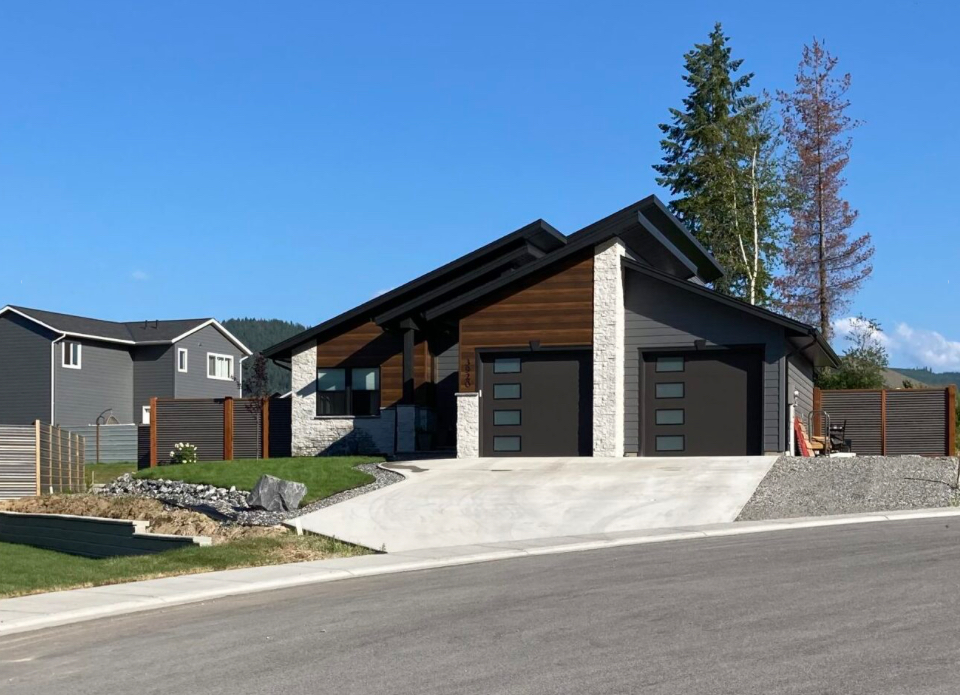 A house with two garage doors and a driveway in front of it