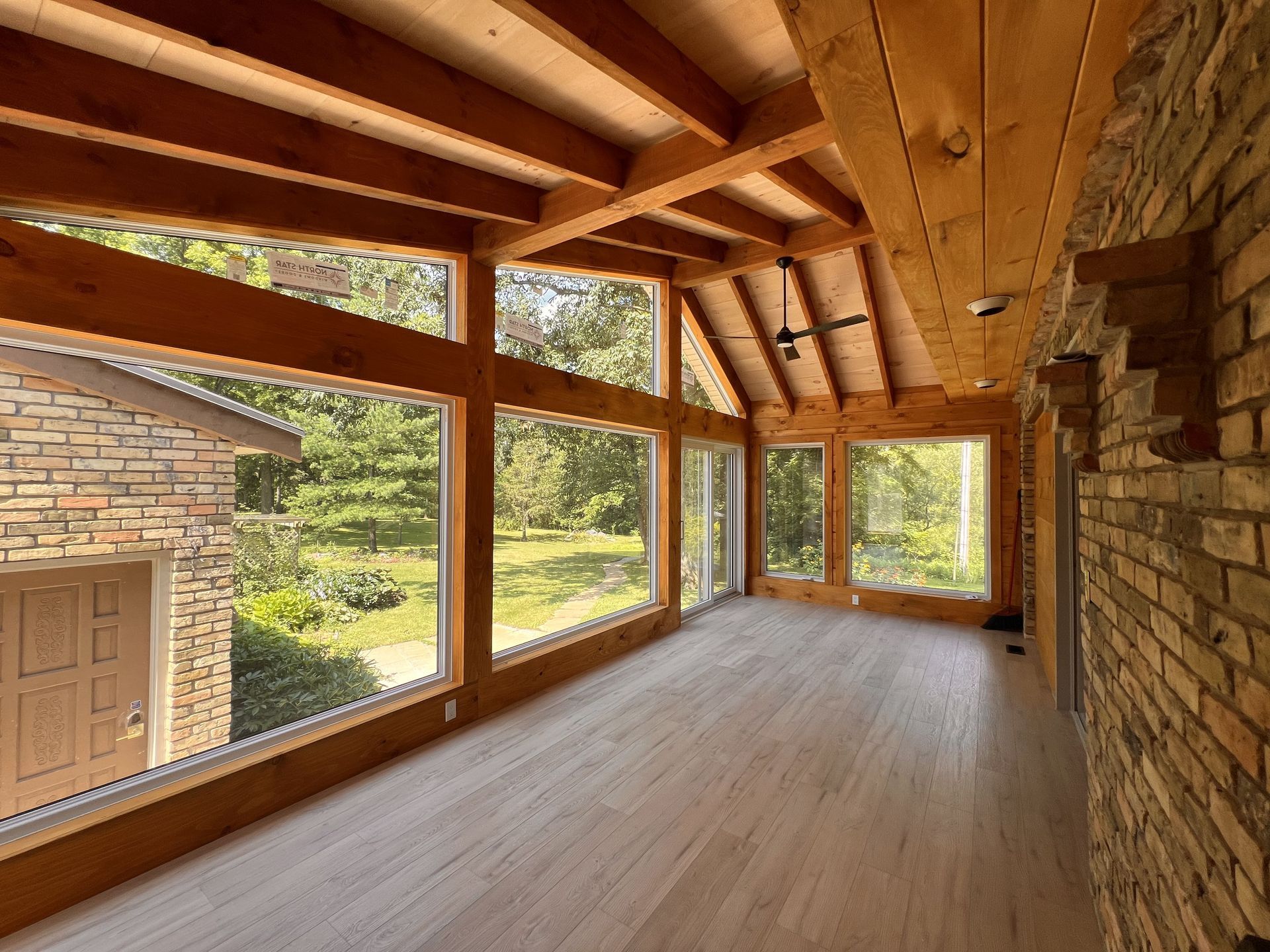 A large room with lots of windows and wooden beams