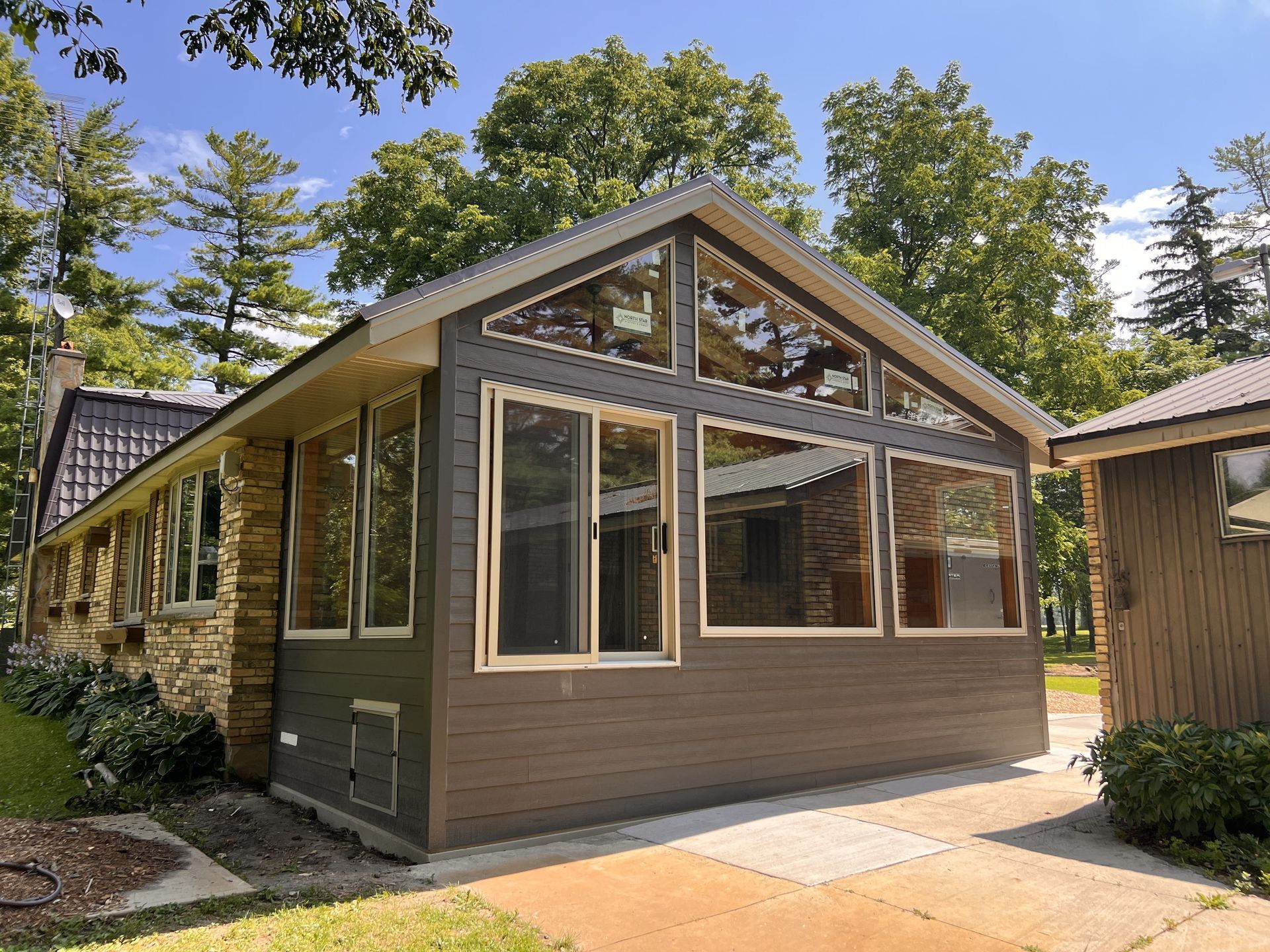 A house with a lot of windows and trees in the background