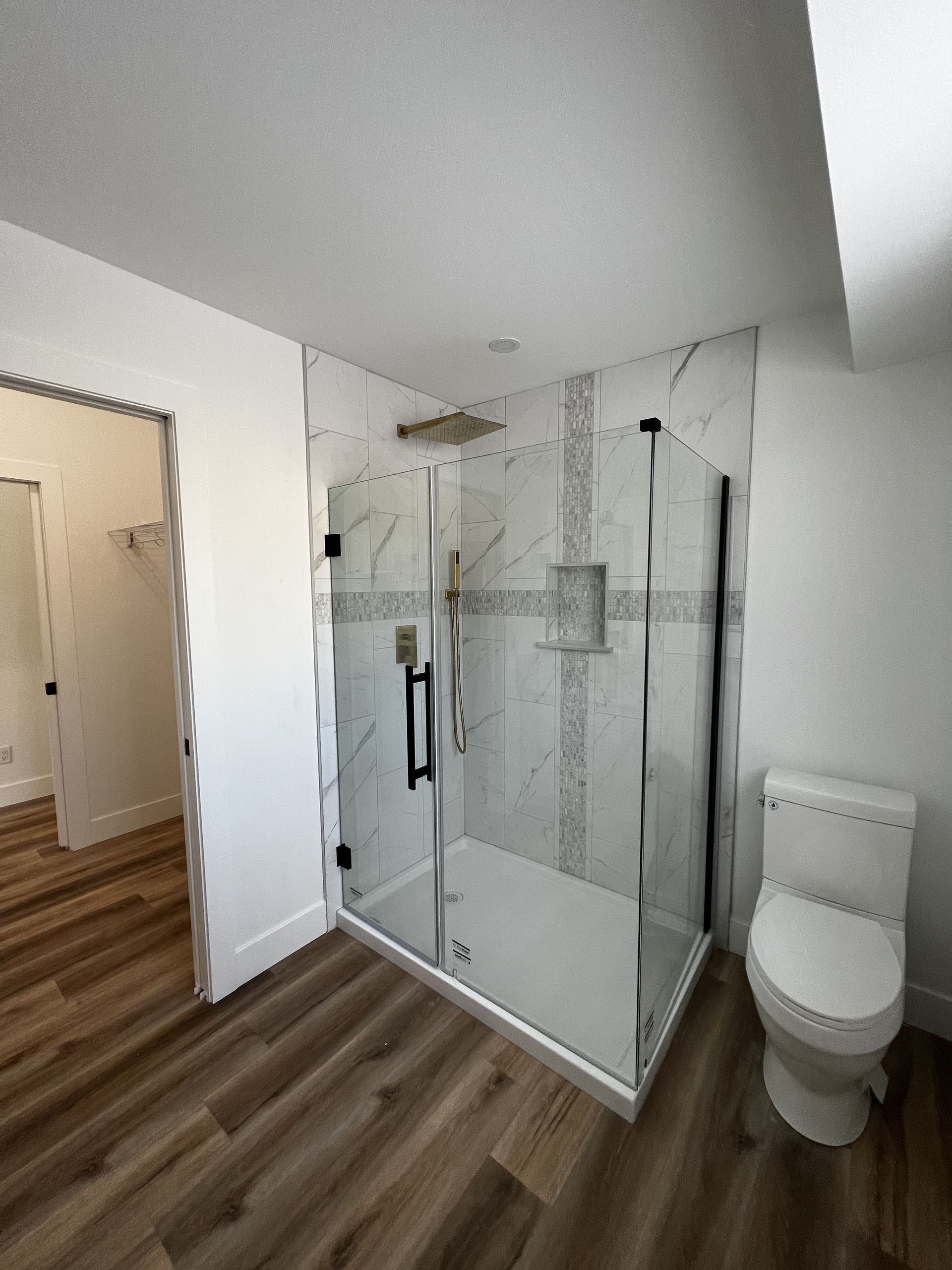 A bathroom with a walk in shower and a toilet.