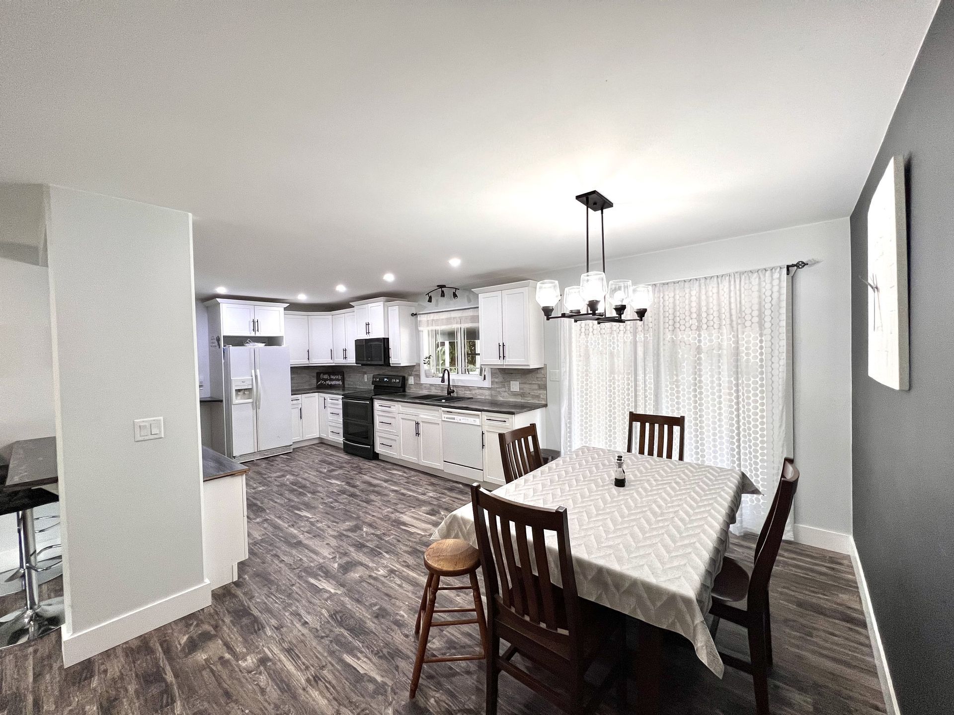A kitchen and dining room in a house with a table and chairs.