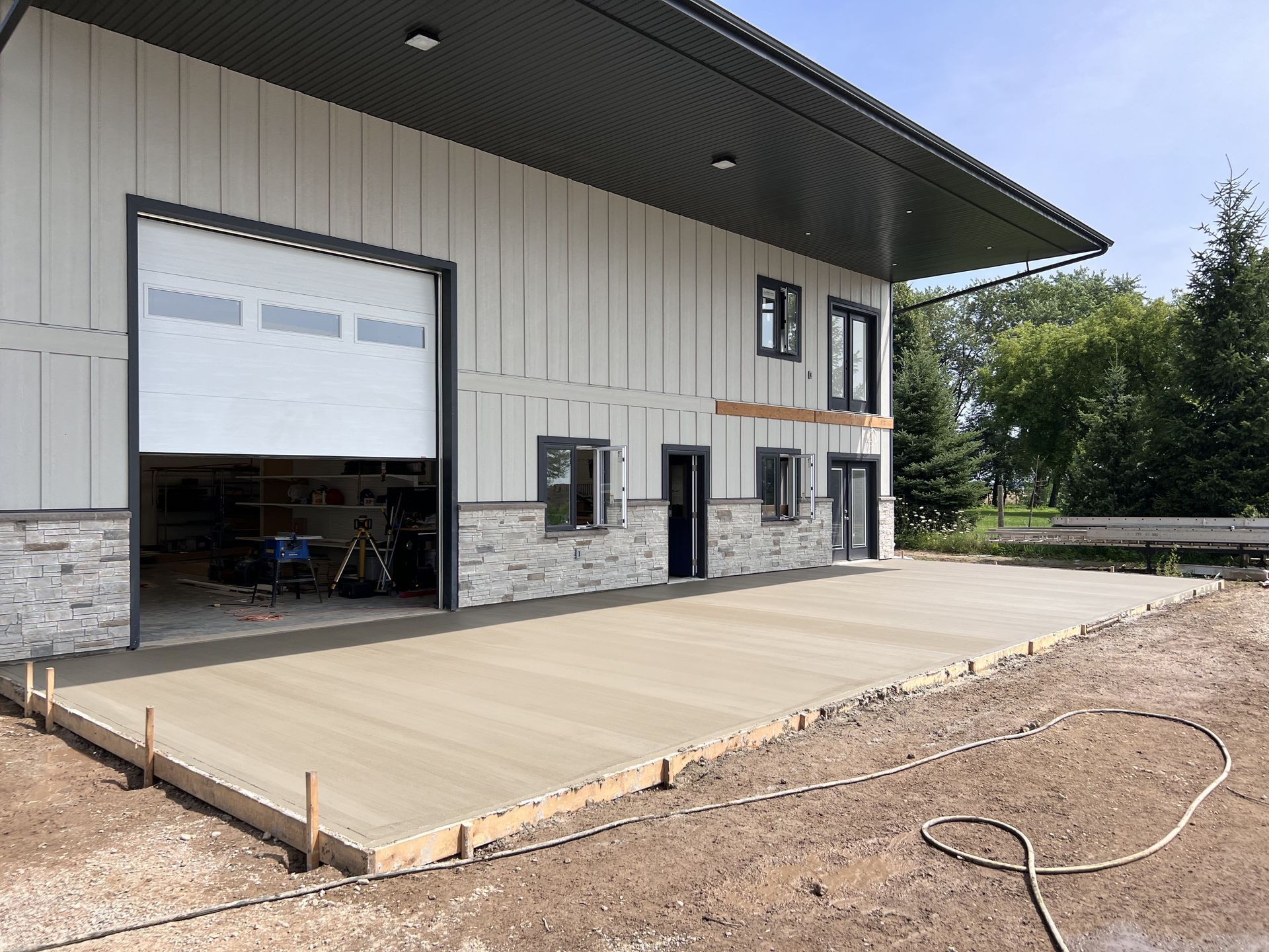 A large building with a large garage door and a concrete driveway in front of it.
