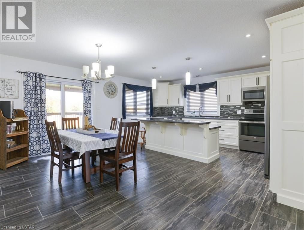 A kitchen and dining room in a house with a table and chairs.