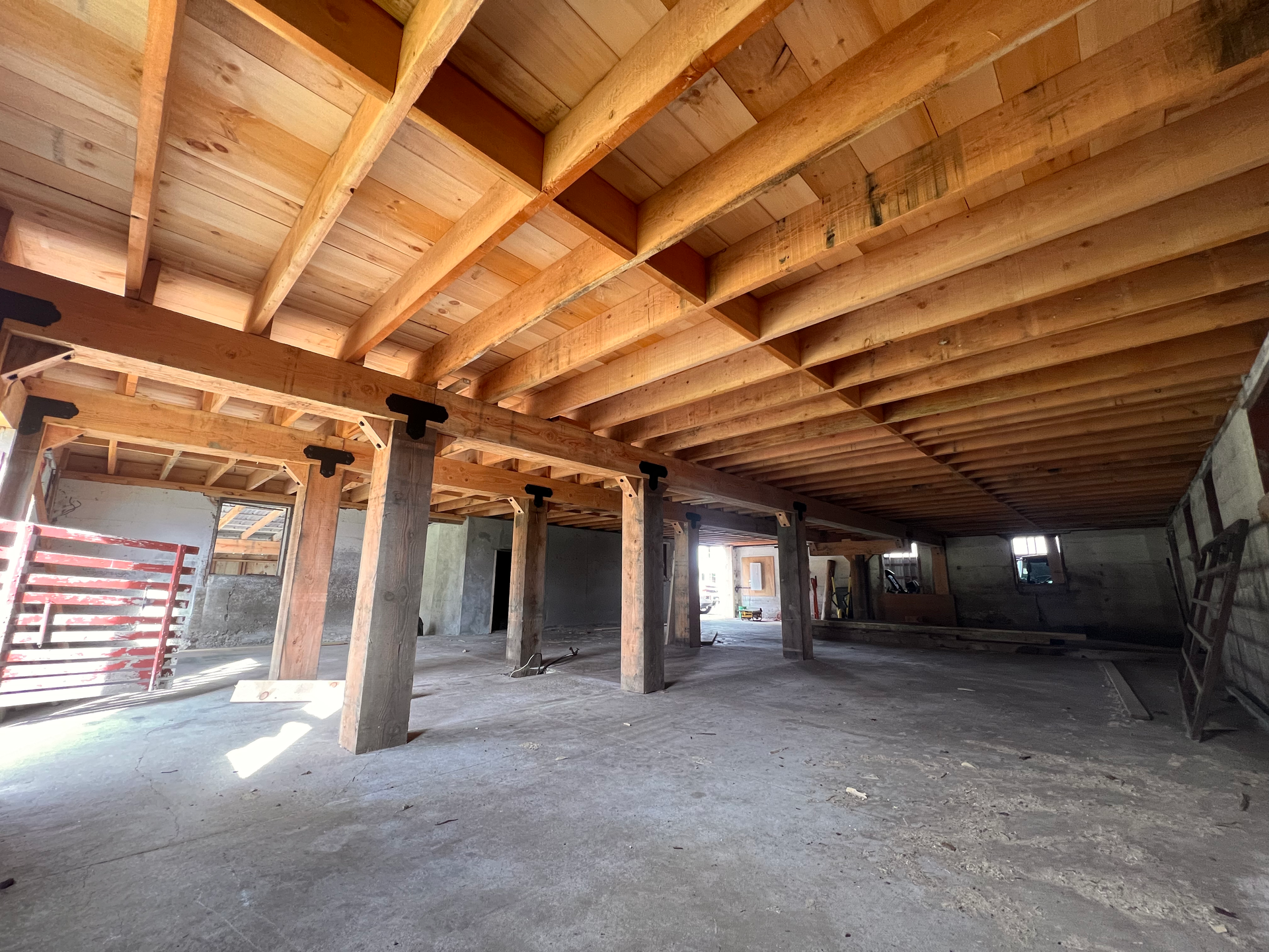 A large empty room with a wooden ceiling and pillars.