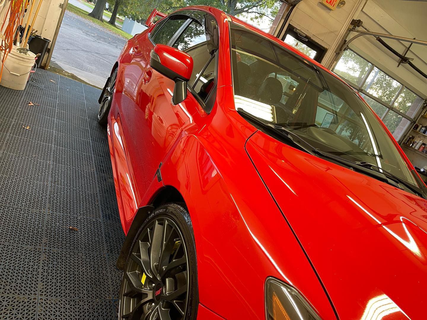 A red car is parked in a garage.