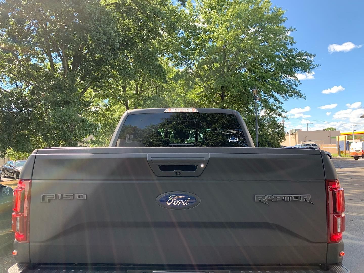 The back of a ford f150 truck is parked in a parking lot.